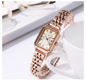 Close-up of a rose gold square watch with roman numerals and stainless steel strap