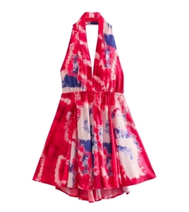 Dettaglio dell'abito allacciato al collo con stampa tie-dye rossa e blu vivace