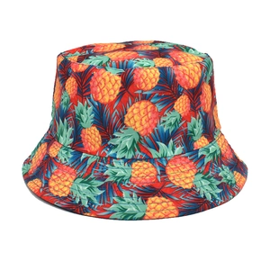 Detail eines roten Anglerhuts mit gelben Ananas-Mustern und tropischen Blattdrucken