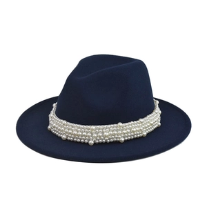 Detalle del aplique de perlas en un sombrero de fieltro de lana azul marino de ala ancha
