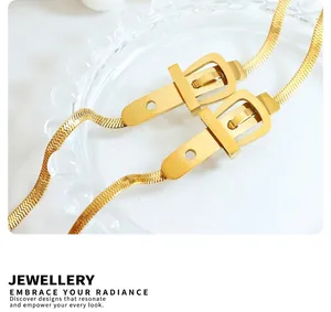 Détail d'un collier chaîne à chevrons dorée avec un fermoir design boucle de ceinture