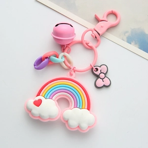 Pink rainbow cloud keychain with a bell, bow and colorful chain on white background