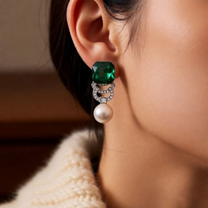 Detailed view of vintage emerald crystal square earrings with pearls on a model
