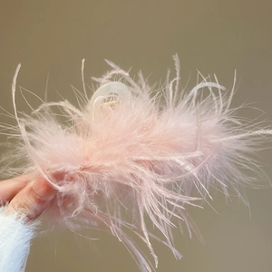 Detail shot of a soft pink feather hair claw clip with delicate acrylic texture