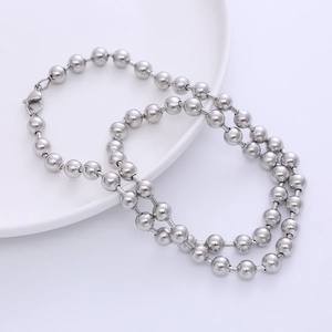 Polished silver stainless steel ball chain necklace with lobster clasp on white plate
