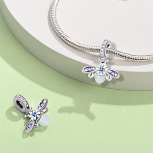Macro view of silver firefly charm with colorful cubic zirconia on snake chain
