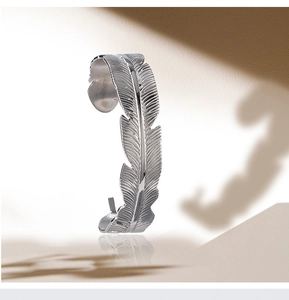 Detailed view of adjustable silver feather cuff bracelet with artistic shadow