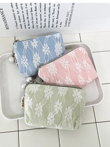 Detailed view of three pastel lace mini pouches with elegant pearl zipper charms and textures