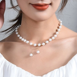 Close-up of double-layer necklace with white pearls and gold chain on model's neck