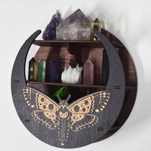 Detail of crescent moon wooden shelf with intricate moth carving and display cubbies
