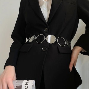 Detail of silver metallic oval waist chain with brushed texture on black blazer