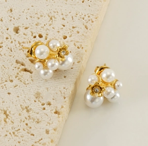 Detail shot of pearl cluster earrings with golden flower accent and sparkling rhinestone