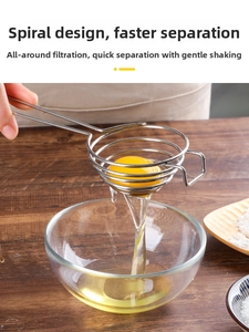Macro view of stainless steel spiral egg separator filtering egg white into a glass bowl