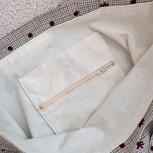 Detailed interior of polka dot canvas tote showing heavy-duty lining and zipper pocket