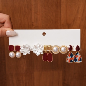 Detailed set of six resin pearl and floral geometric earrings displayed on a card