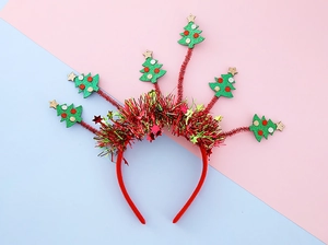 Détail du serre-tête de Noël avec sapin à paillettes vertes et glands colorés sur rose