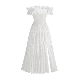 Close-up of white off-the-shoulder lace dress with eyelet embroidery and tiered skirt detail