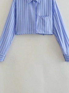 Détail d'une chemise courte à rayures bleues et blanches avec tissu texturé et poche