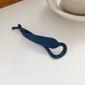 Vue détaillée d'une pince à cheveux banane bleu foncé mat sur fond minimaliste