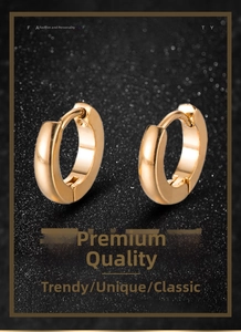 Detailed view of gold minimalist huggie hoop earrings on black textured background