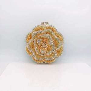Macro shot of gold and silver flower evening bag with crystal rhinestones on white display