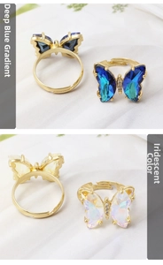 Close-up of butterfly rings in dark blue gradient and iridescent crystal finishes