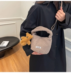 Détail du sac seau en laine d'agneau taupe avec pendentif ours et bandoulière marron