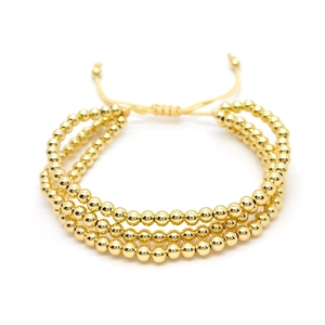 Three-layer stacked gold bead bracelet with adjustable woven cord for a minimalist look