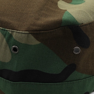 Macro detail of jungle camouflage cotton fabric and dark metal ventilation eyelets
