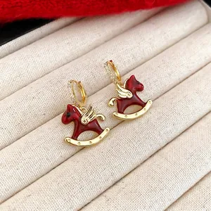 Boucles d'oreilles cheval à bascule en émail rouge avec ailes dorées et zircons