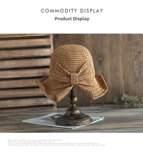 Detalle de un sombrero de paja caqui con lazo sobre un soporte de estilo vintage