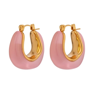 Detail of pink resin and 18k gold U-shaped earrings with polished metal interior