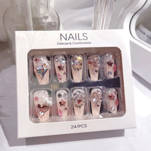 Detailed view of luxury pink press-on nails with sparkling heart and bow rhinestones