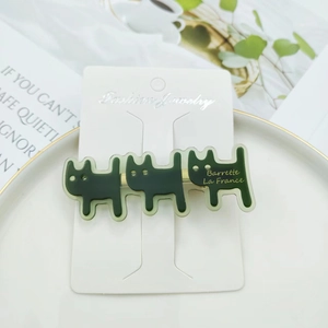 Detailed close-up of dark green acetate cat hair clip with golden Barrette La France text