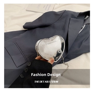Detail of silver heart-shaped mirror bag with chain strap and fashion lettering