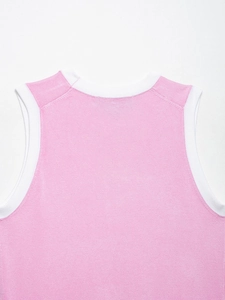 Détail du débardeur en maille rose montrant le col rond et la bordure côtelée blanche