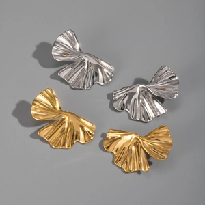 Detailed view of silver and gold ginkgo leaf earrings with fluid textured metal finish