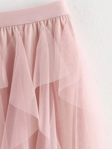 Detail view of pink mesh fabric layers and ruffled tiers on long holiday skirt