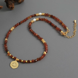 Handmade beaded necklace with natural brown stones, freshwater pearls and evil eye pendant