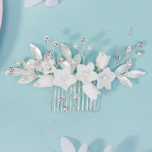 Handmade bridal hair comb with white ceramic flowers, pearls and silver leaves on blue background