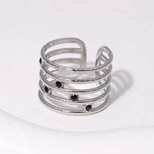 Detail of silver multilayer spiral steel ring with black dot accents and hammered texture