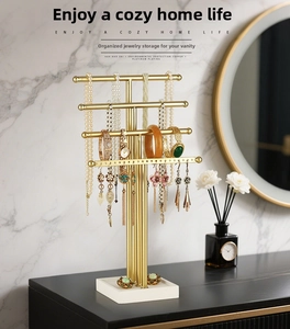Detail of 4-tier golden jewelry rack on a black vanity with elegant home decor