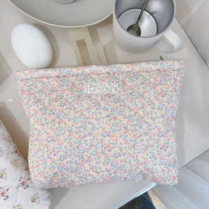Quilted cotton makeup bag with floral pattern and Simple Wish label on white table
