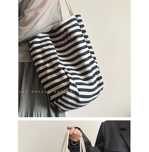 Detail of blue and white striped canvas tote bag with red fox embroidery and top handles