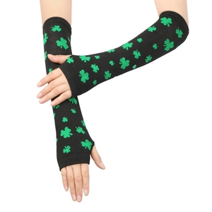 Detail of knitted arm warmers featuring green shamrock patterns on black fingerless gloves
