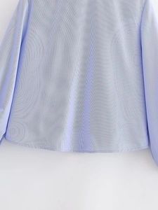 Detailed macro view of light blue and white striped poplin shirt fabric and hemline