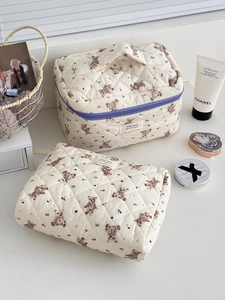 Detail of quilted cosmetic bag set featuring purple bear and floral prints with soft handles