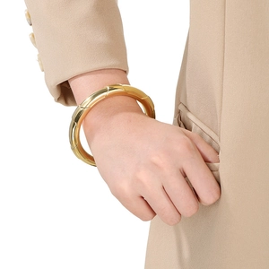 Detailed view of a gold-plated stainless steel cuff bracelet with quilted geometric pattern