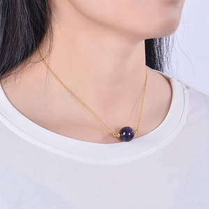 Minimalist gold necklace featuring a 16mm round purple crystal pendant worn on a model