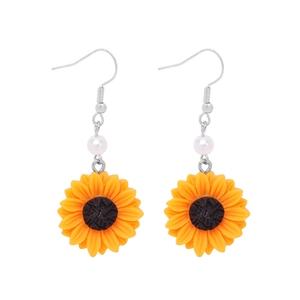 Detail of sunflower drop earrings with yellow petals, white pearl beads, and silver hooks